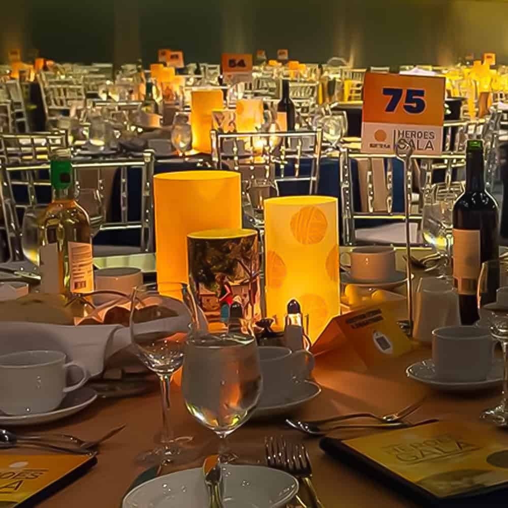 Trio of illuminated open shade centerpieces for a Gala event featuring event theme colors and logos.